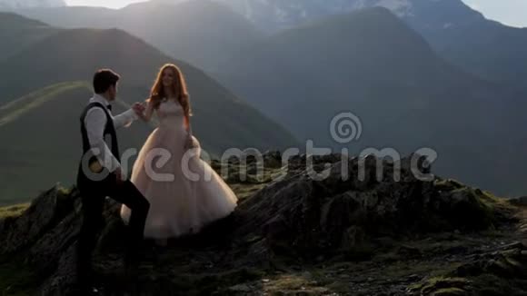 夕阳西下一位壮丽的新娘和新郎在雄伟的山脉的背景下格鲁吉亚这就是视频的预览图