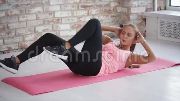 女人躺在运动垫上做腿部和按压的体育锻炼视频的预览图