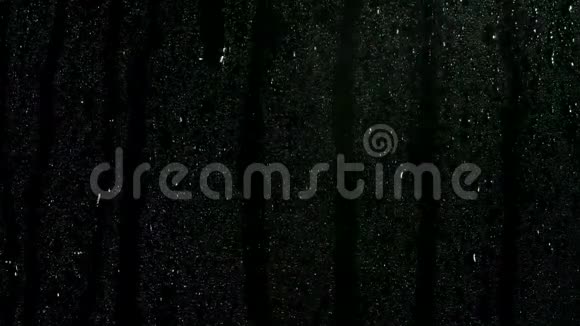 许多小水滴在黑色的玻璃卷发下来的黑色背景窗户凝结库存录像关门视频的预览图