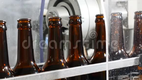 机器人触摸啤酒厂生产机器的特写镜头空啤酒瓶在传送带上技术路线视频的预览图