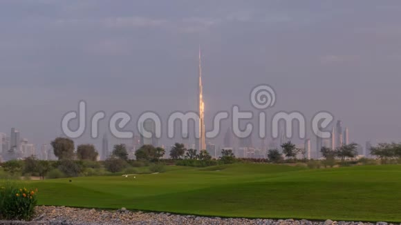美丽的高尔夫球场日出时围绕迪拜市区的现代化摩天大楼在豪华的迪拜城联合视频的预览图
