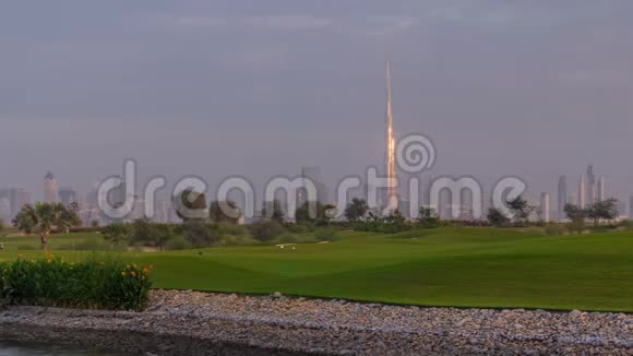 美丽的高尔夫球场日出时围绕迪拜市区的现代化摩天大楼在豪华的迪拜城联合视频的预览图