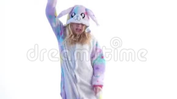 现代时尚美丽的金发女孩在白色背景上穿着kigurumi睡衣兔子服装隔离在视频的预览图