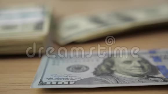 商人的手在桌子上数着一百美元的钞票视频的预览图