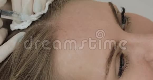 年轻有魅力的女人接受头发的中间疗法女孩头部受到注射快关门视频的预览图