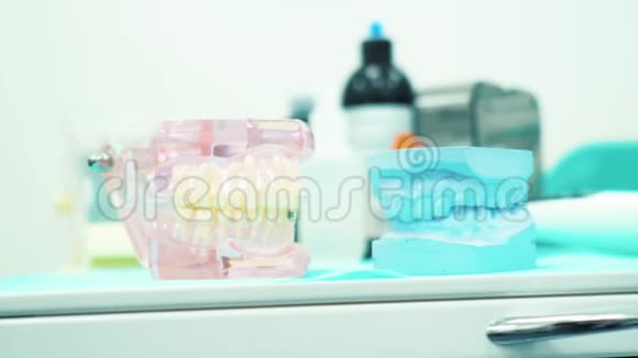 在一个牙科医生的柜子里特写粉红色和蓝色的假牙假肢器具视频的预览图