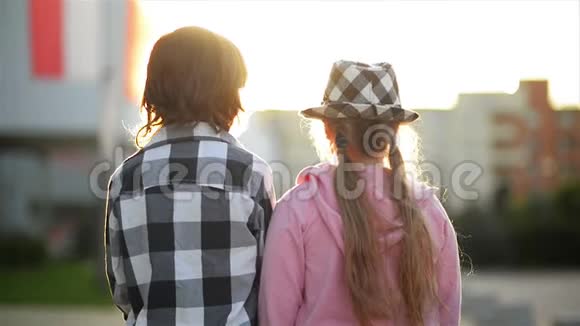 两个孩子互相看着笑女孩有一顶时髦的帽子视频的预览图