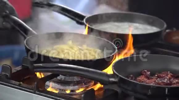 炒锅着火厨师炒蔬菜着火把它们扔进煎锅里视频的预览图