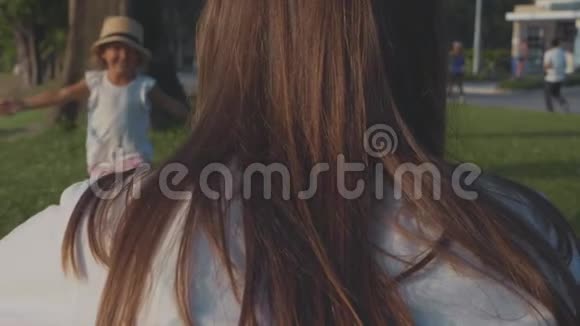 小孩子跑进她妈妈身边她在公园里缓慢地拥抱视频的预览图