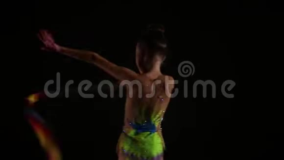 漂亮可爱的小女孩运动员穿着鲜艳的泳衣用丝带表演艺术体操元素视频的预览图