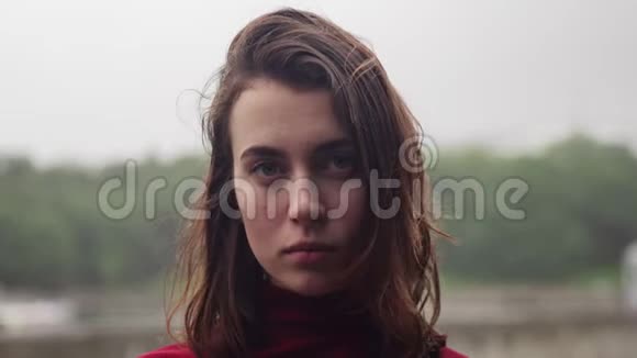 年轻女子脸上带着悲伤的神情雨中湿发多云的坏天气视频的预览图