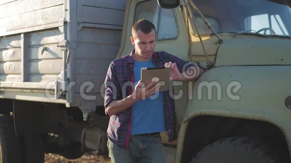 农民靠在卡车上使用数字平板电脑视频的预览图