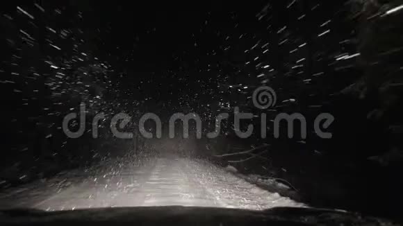 汽车正沿着一条森林覆盖着雪的道路行驶视频的预览图