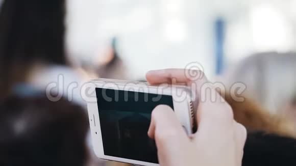 一个女人用一只手拿着手机拍了一段视频音乐会上的娱乐活动视频的预览图
