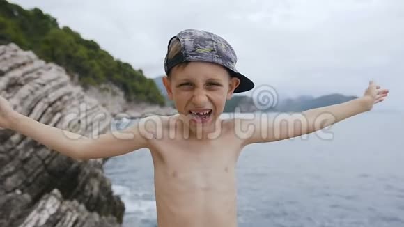 小男孩闭上眼睛用手发现他的眼睛一个戴着帽子的快乐孩子在海底的肖像视频的预览图