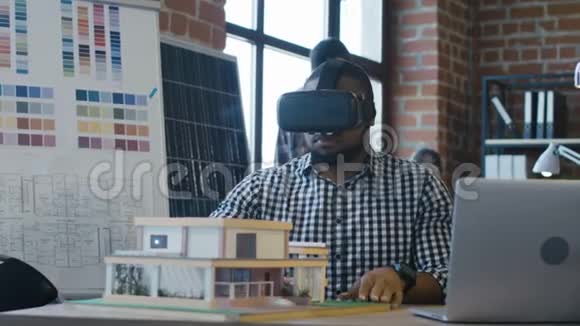 戴着VR眼镜的黑人创造房子模型视频的预览图