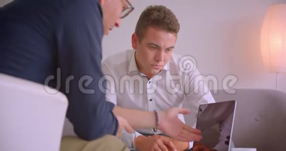 两位成功的高加索商人在办公室里坐在扶手椅上开会的画像视频的预览图