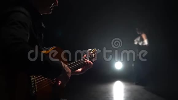 吉他手演奏弗拉门戈女孩跳舞从后面的光烟雾黑背景视频的预览图