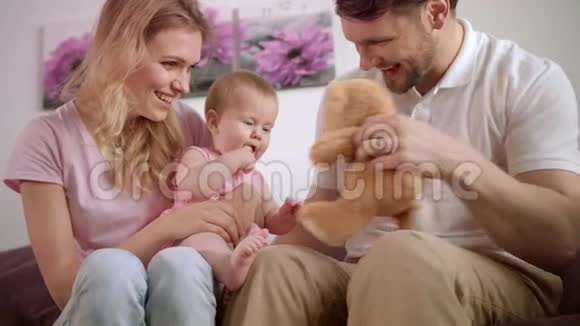 一家人和玩具熊一起玩有孩子的母亲和父亲视频的预览图