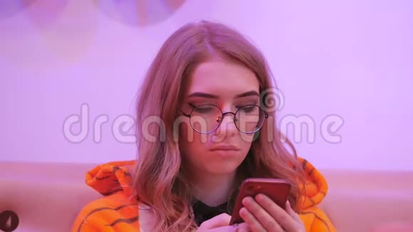 少女动画师穿成老虎坐在咖啡馆里使用智能手机视频的预览图