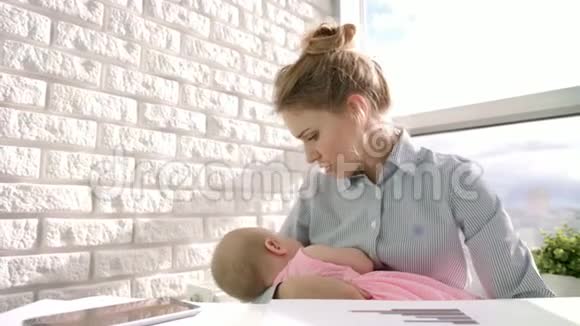 商务女性在灯光窗口照顾婴儿有孩子的工作妈妈视频的预览图
