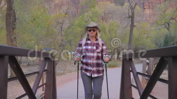 活动女性徒步穿越美国锡安公园的河桥慢动作4K视频的预览图