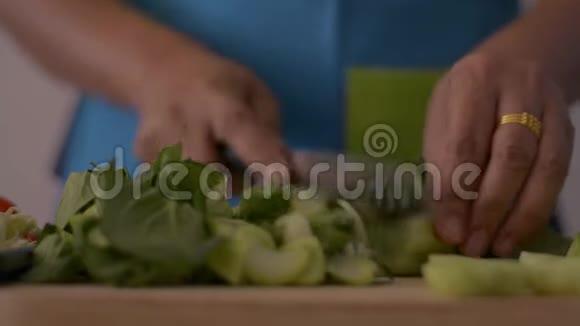 近镜头的女人手切婴儿博克霍伊在木切割板上的健康食品在桌子上视频的预览图