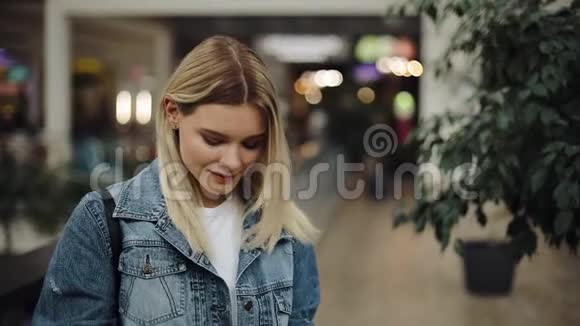 女孩看着站在商场里的购物袋视频的预览图