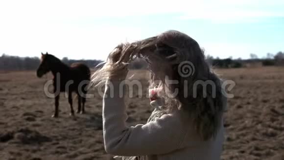 一个年轻漂亮的女人关心和骑她的马视频的预览图