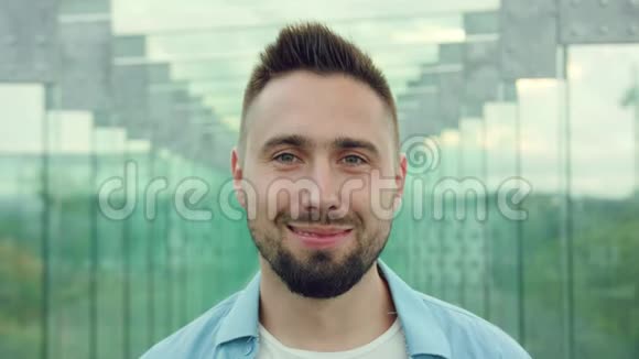 幸福的微笑男人与胡子在玻璃大厦视频的预览图
