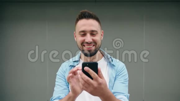戴胡子的男人用电话对付灰色背景视频的预览图