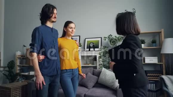男人和女人从房产经纪人手里拿钥匙说话接吻握手视频的预览图