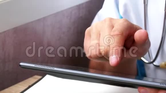 男医生他的手使用他的现代数字平板电脑视频的预览图