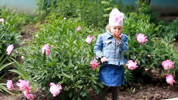 小女孩送空气吻花园里有牡丹和有趣的婴儿视频的预览图