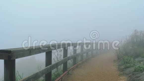 雾和大风沿着木栏杆沿着远足小径滚动视频的预览图