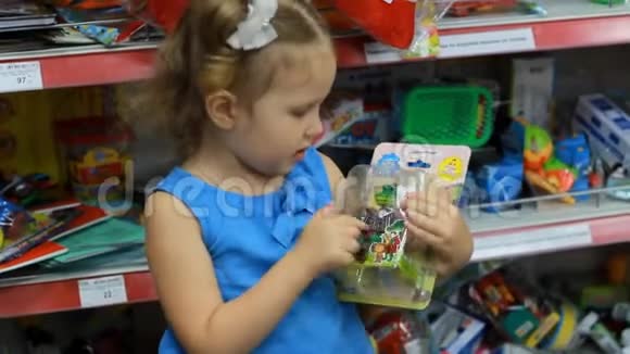 超市里的小女孩为自己选择了一个玩具孩子购物视频的预览图