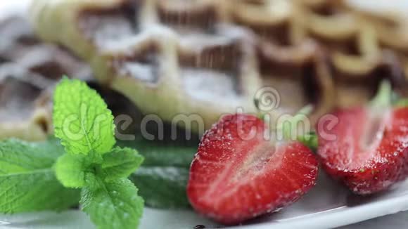 比利时华夫饼盘子里放着新鲜草莓厨师手洒甜点糖粉视频的预览图