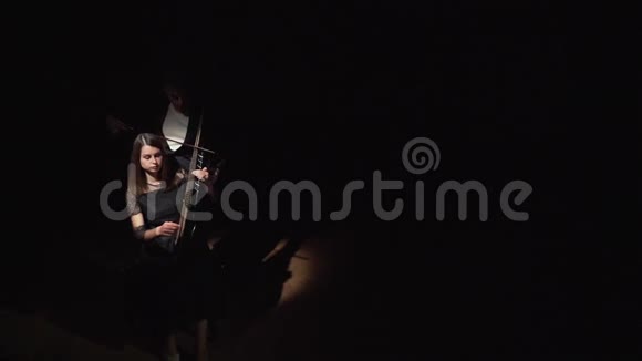 音乐家女孩和男孩在黑暗的房间里演奏手风琴和绷带视频的预览图