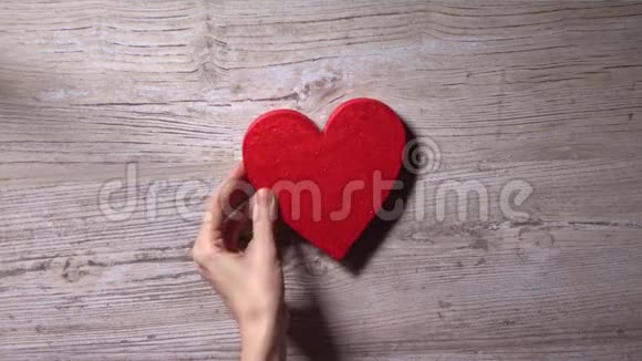 女孩把红心放在木桌上俯视浪漫爱情情人节孤独的概念4K视频视频的预览图