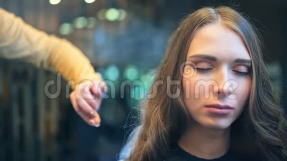 专业女性理发师在客户头发上喷洒喷雾剂视频的预览图