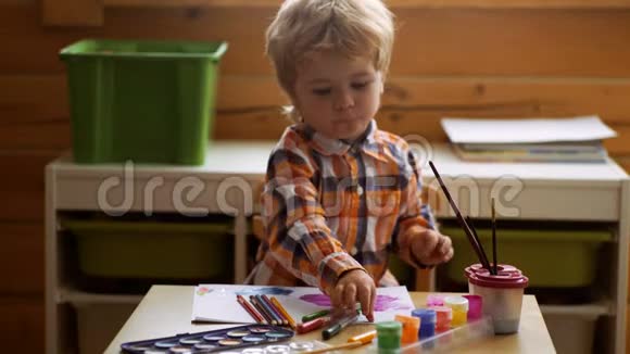 可爱的小男孩在他的相册里画画幼儿教育绘画天赋幸福家庭和养育子女的概念视频的预览图