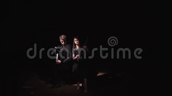 音乐家女孩和男孩在黑暗的房间里演奏手风琴和绷带视频的预览图