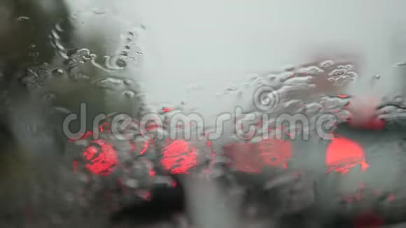 雨天驾驶汽车斜挡风玻璃上雨的选择性聚焦和离焦背景视频的预览图