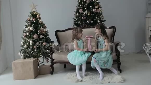 年轻快乐的微笑女孩送和玩圣诞礼品盒视频的预览图