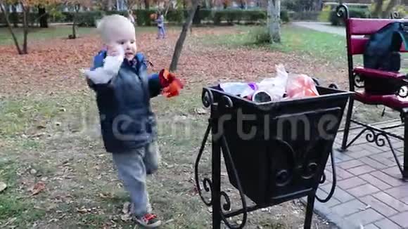 一个小男孩在街上的垃圾桶里扔垃圾废物管理和环境保护的理念适当的做法视频的预览图