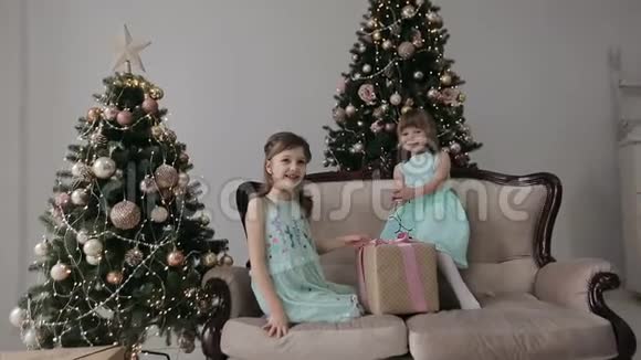 年轻快乐的微笑女孩送和玩圣诞礼品盒视频的预览图
