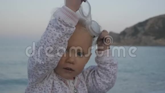 海背景下调皮的白种人金发女孩摘下泳镜的肖像视频的预览图