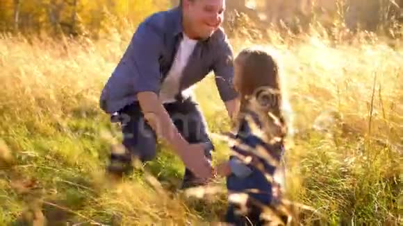 有魅力的年轻人在大自然中和他的女儿玩视频的预览图