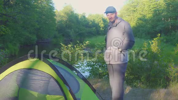 4k夏天森林里一个人站在河边的帐篷附近视频的预览图