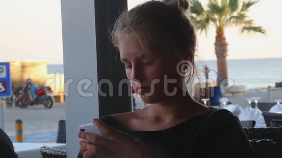 时髦的女孩坐在海滩餐厅视频的预览图